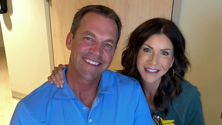 Bryon Noem and Kristi Noem smiling in a hallway.