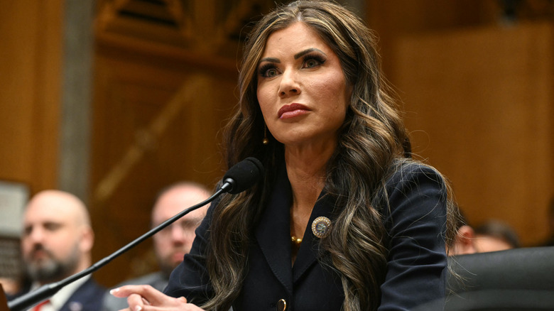 Kristi Noem sitting at microphone