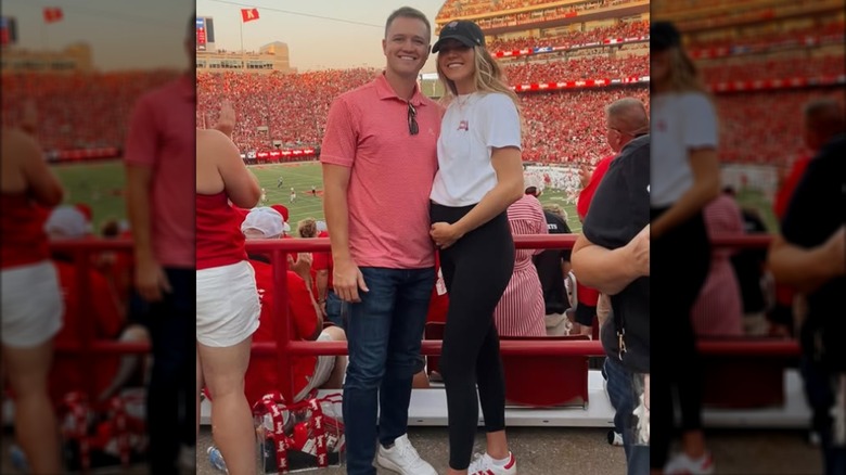 Kennedy Frick and her husband Tanner Frick pose together at a football game.