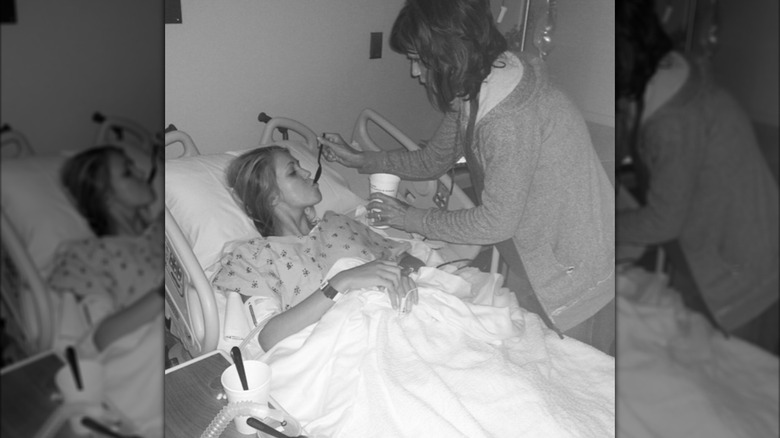 Kristi Noem feeding Kennedy Frick in a hospital bed.