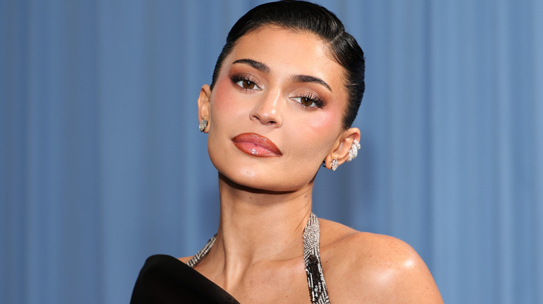 Kylie Jenner posing in front of a blue background