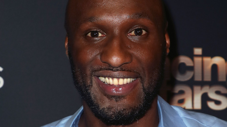 Lamar Odom smiles in a blue dress shirt