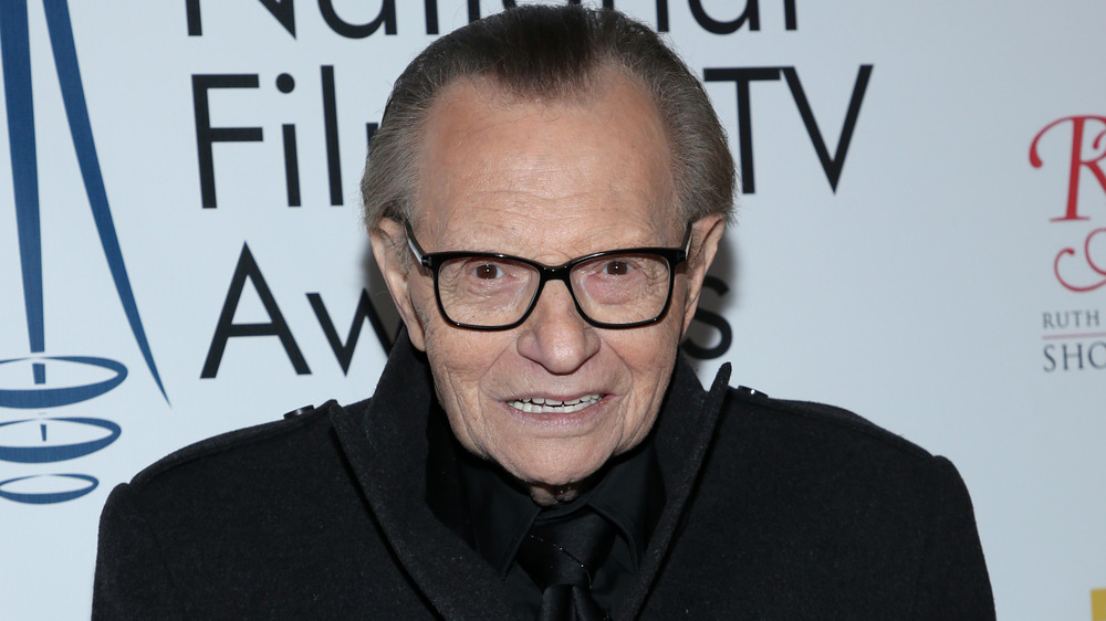 Larry King smiling on the red carpet