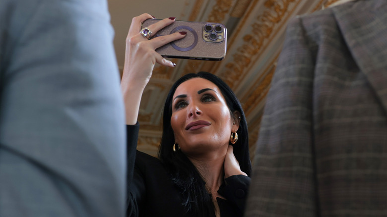 Laura Loomer smiling recording on her phone
