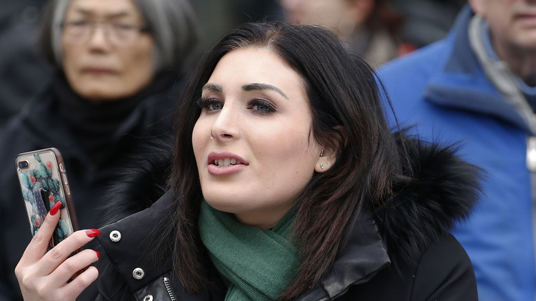 Laura Loomer holds her phone during the Women's March 2019