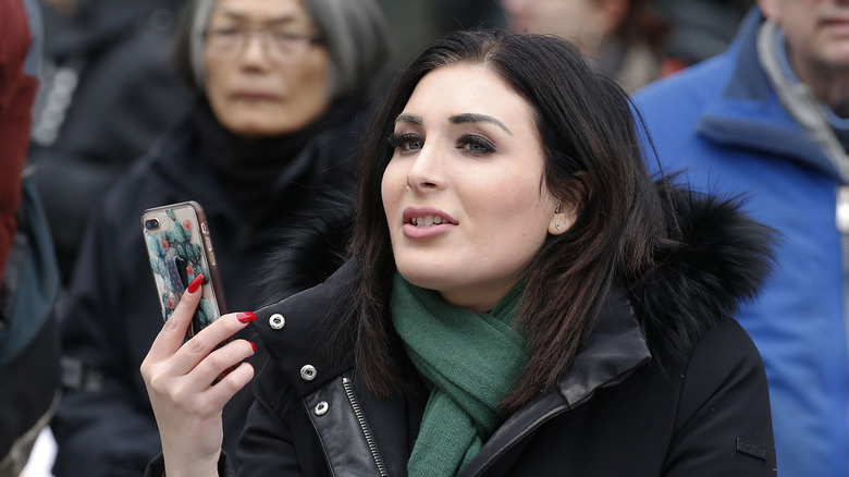 Laura Loomer holding a phone