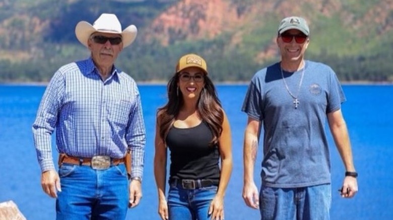 Lauren Boebert poses with dam workers in a black tank top