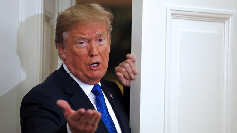 Donald Trump holding a door open
