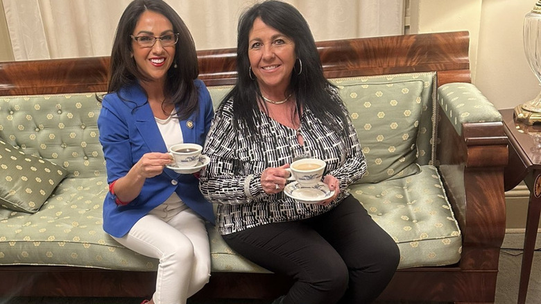 Lauren Boebert and Shawna Bentz sit in couch holding cup and saucers