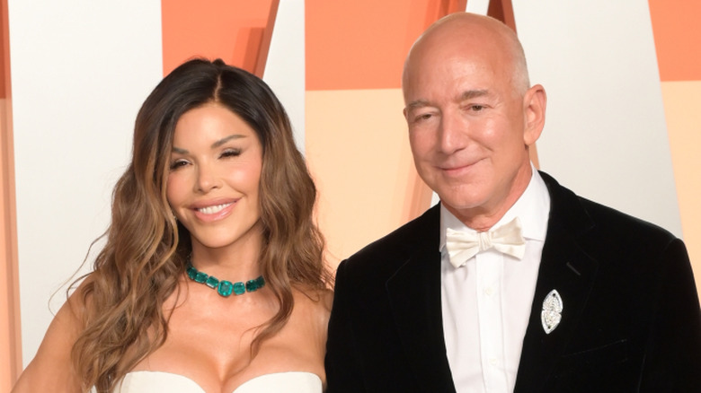 Lauren Sanchez in white strapless dress, smiling next to Jeff Bezos in black tux