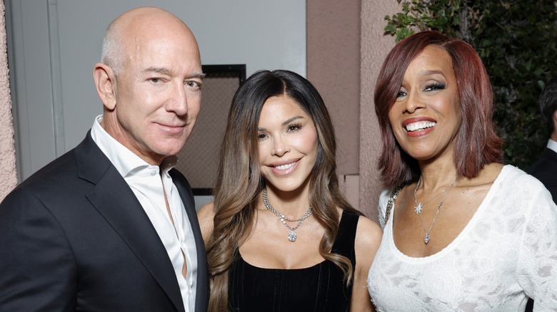 Lauren Sánchez smiles and stands between Jeff Bezos and Gayle King.