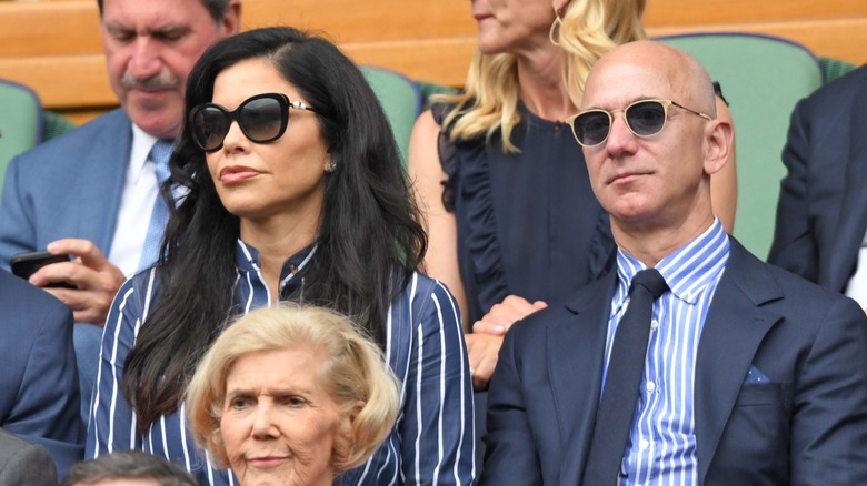 Lauren Sánchez sits next to Jeff Bezos amid a crowd watching a tennis match.