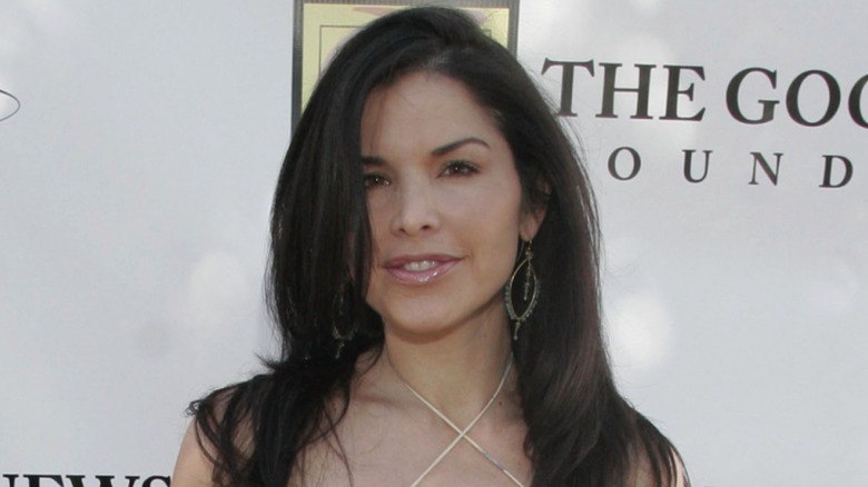 Lauren Sánchez poses for a photo in a sundress with a crisscross neckline and hoop earring.