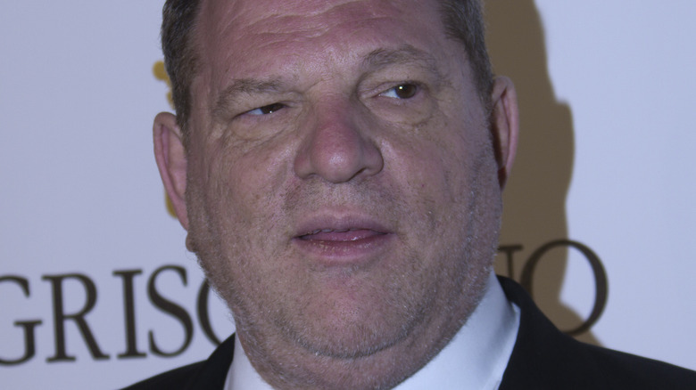 Harvey Weinstein one eye squinting tongue between his lips