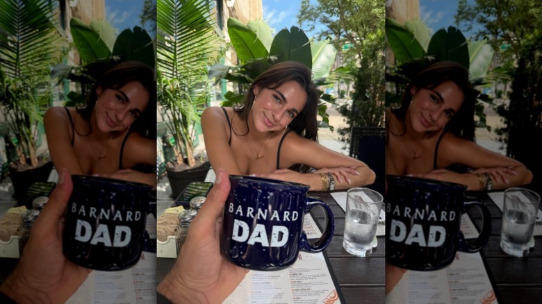 Cameron Mathison holds Barnard Dad mug in front of Leila