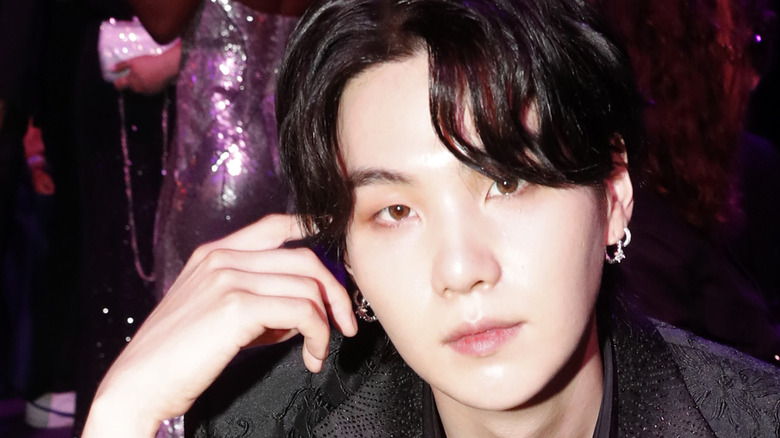 SUGA posing hand on head