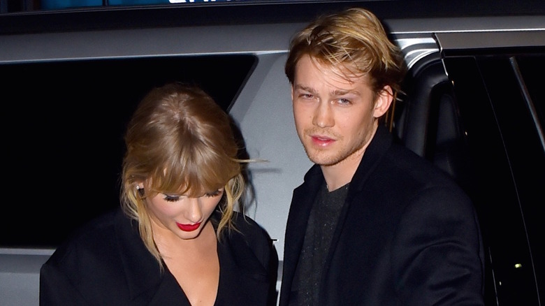 Taylor Swift looking down beside Joe Alwyn