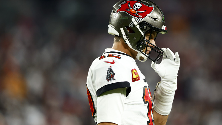 Tom Brady adjusting his helmet during a football game