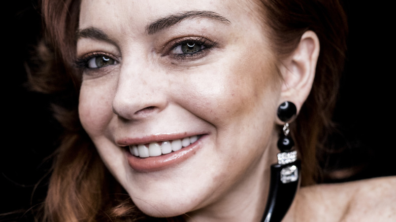 Lindsay Lohan smiles wearing black drop earring