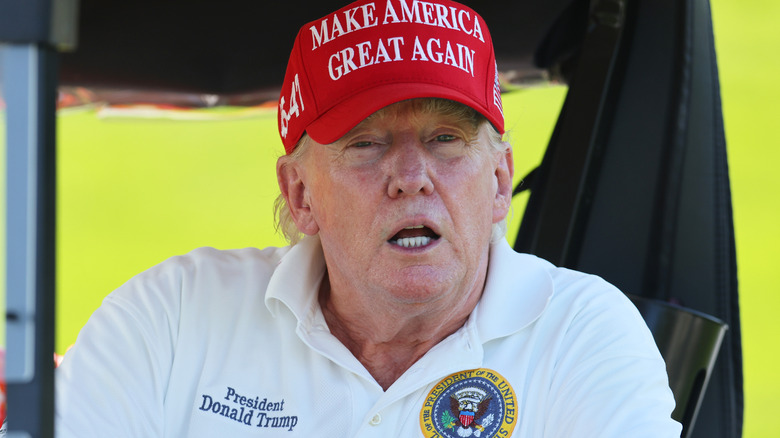 Donald Trump sitting in a golf cart