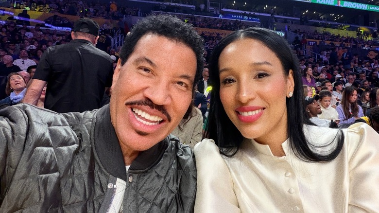 Lisa Parigi and Lionel Richie take a selfie at basketball game