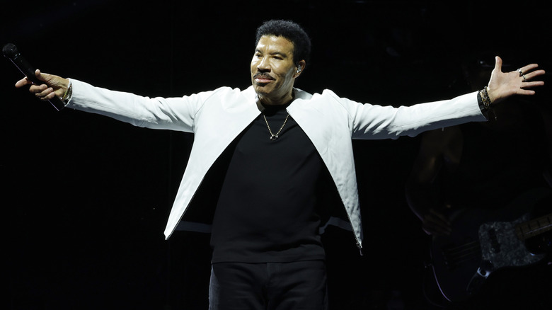 Lionel Richie holding a mic and standing on stage.