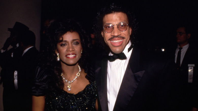 Lionel Richie wearing a tux and posing with his first wife Brenda Harvey Richie