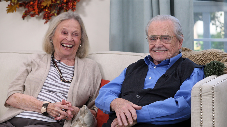 Bonnie Bartlett and Williams Daniels laughing together on a couch during an interview in 2017.