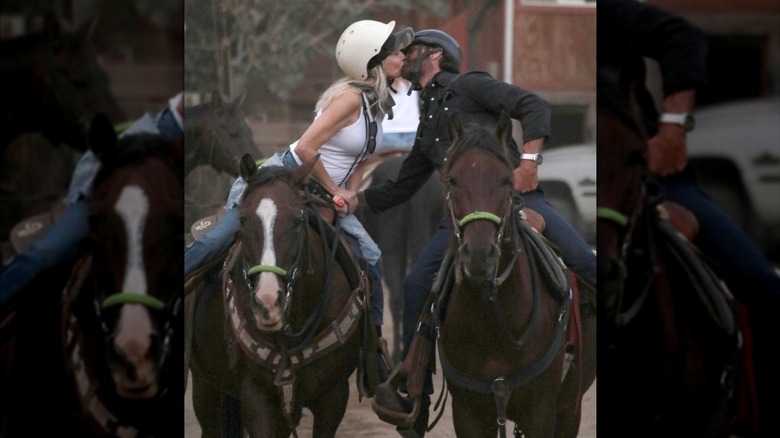 Lorenzo Lamas and Heather Locklear kissing while sitting on horses.