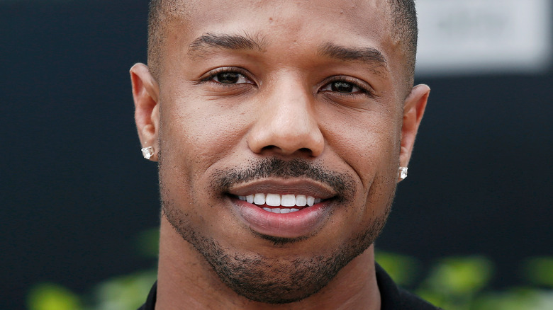 Michael B. Jordan smiling with earrings