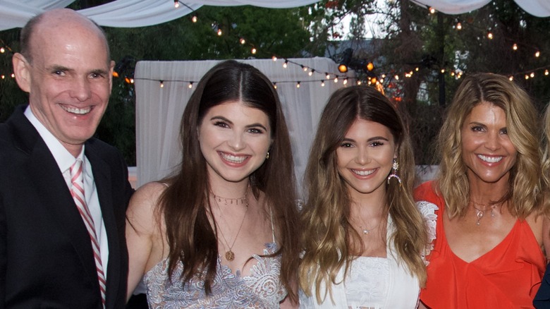 Bill Abbott posing with Lori Loughlin and her daughters