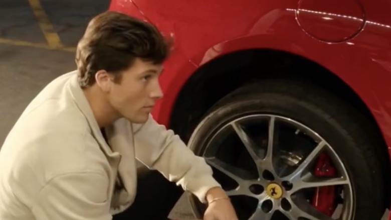 Rob Rausch about to change a tire in a still from Maintenance Required