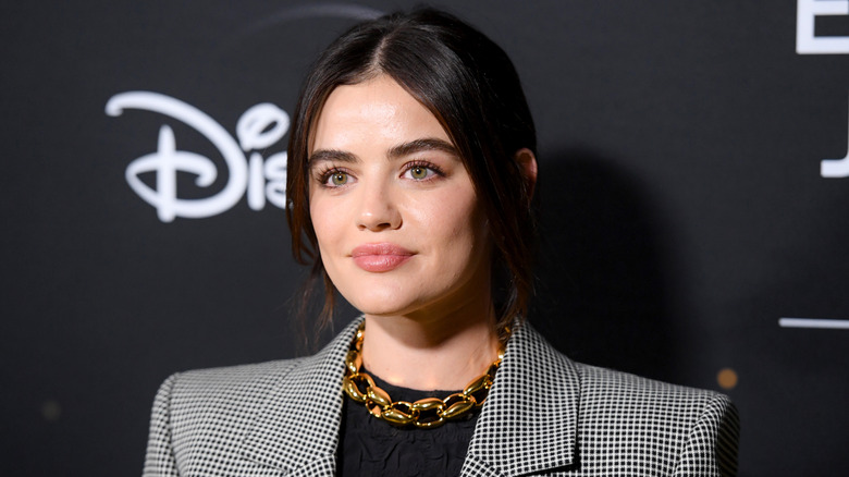 Lucy Hale in a checkered blazer and gold chain necklace