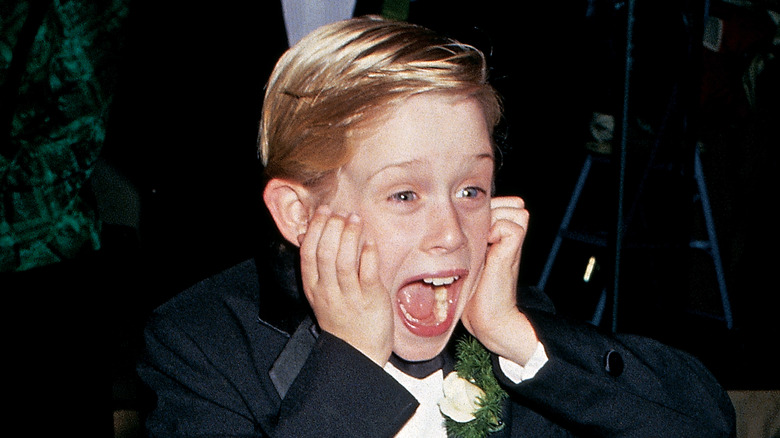 MaCaulay Culkin posing with hands on face