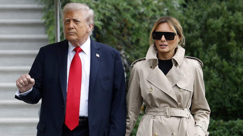 Donald and Melania Trump holding hands.