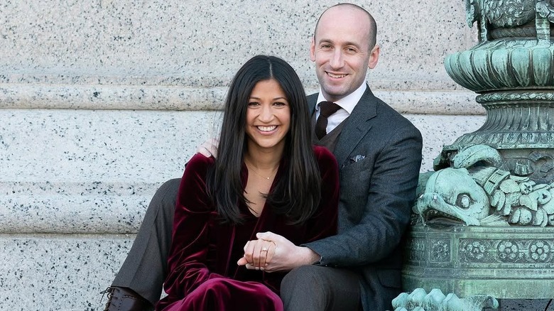 Katie Miller and Stephen Miller set on steps and smile