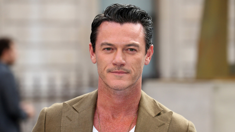 Luke Evans posing in front of a building