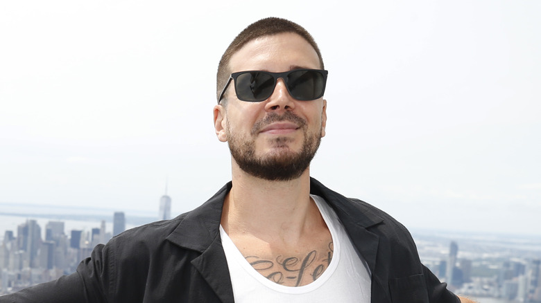 Vinny Guadagnino posing in front of a cityscape 