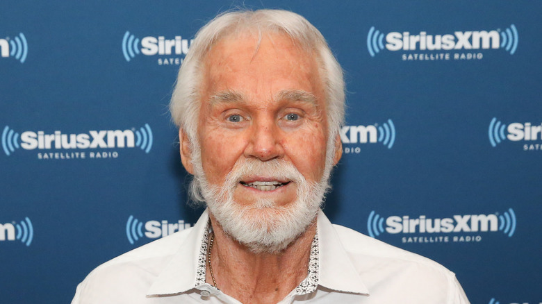 Kenny Rogers smiling in front of a Sirius XM background