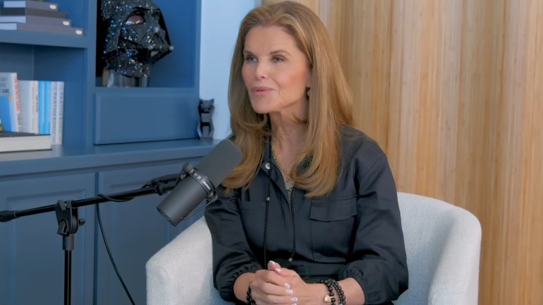 Sporting a gray collared outfit, Maria Shriver speaks into a microphone
