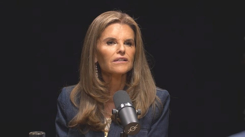 Maria Shriver is lit by a spotlight as she speaks into a microphone