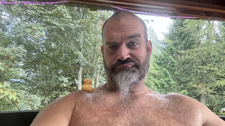 Craig Ivey poses shirtless with a toy duck on his shoulder