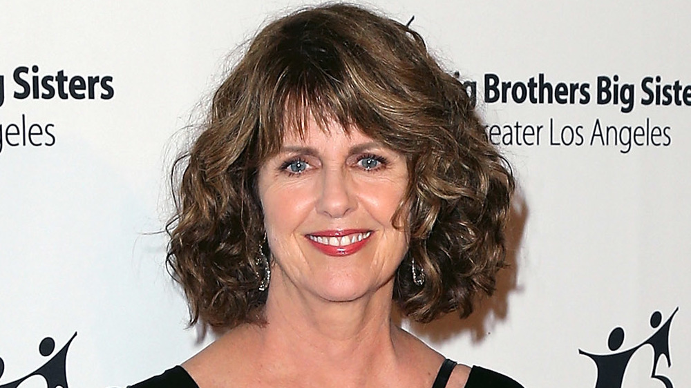 Pam Dawber with curly hair posing on the red carpet