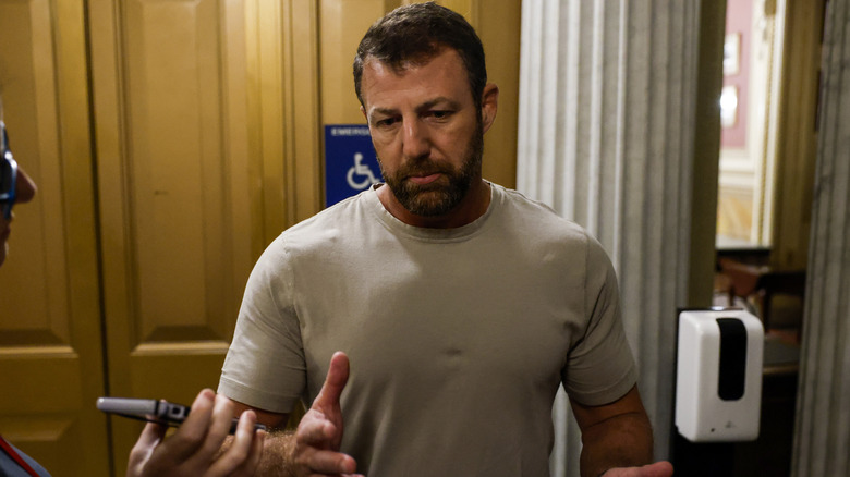 Markwayne Mullin speaking to reporters in 2023 in an off-grey T-shirt