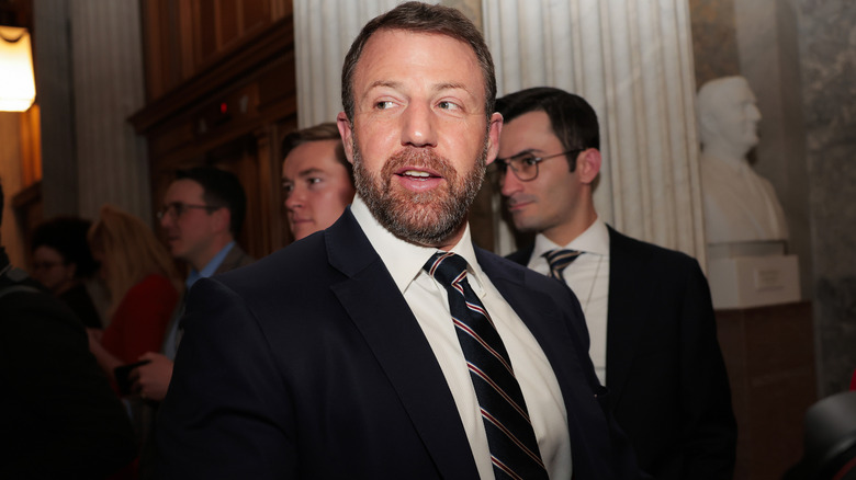Markwayne Mullin pictured looking sideways at the Capitol in a black suit