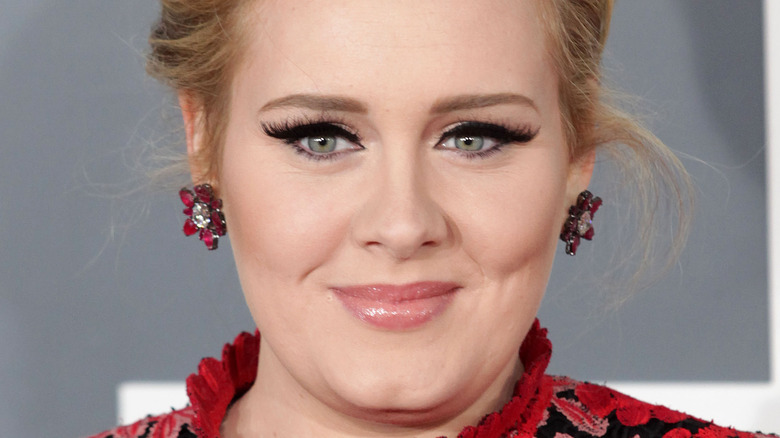 Adele smiling red rose earrings black eyeliner