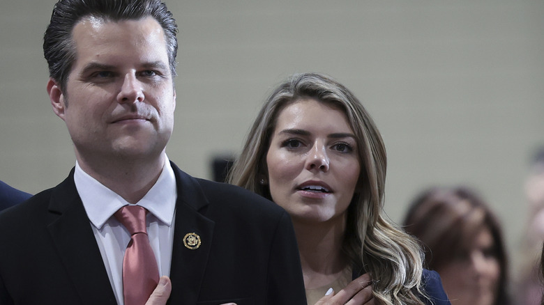 Ginger Gaetz standing behind Matt Gaetz with hands over heart