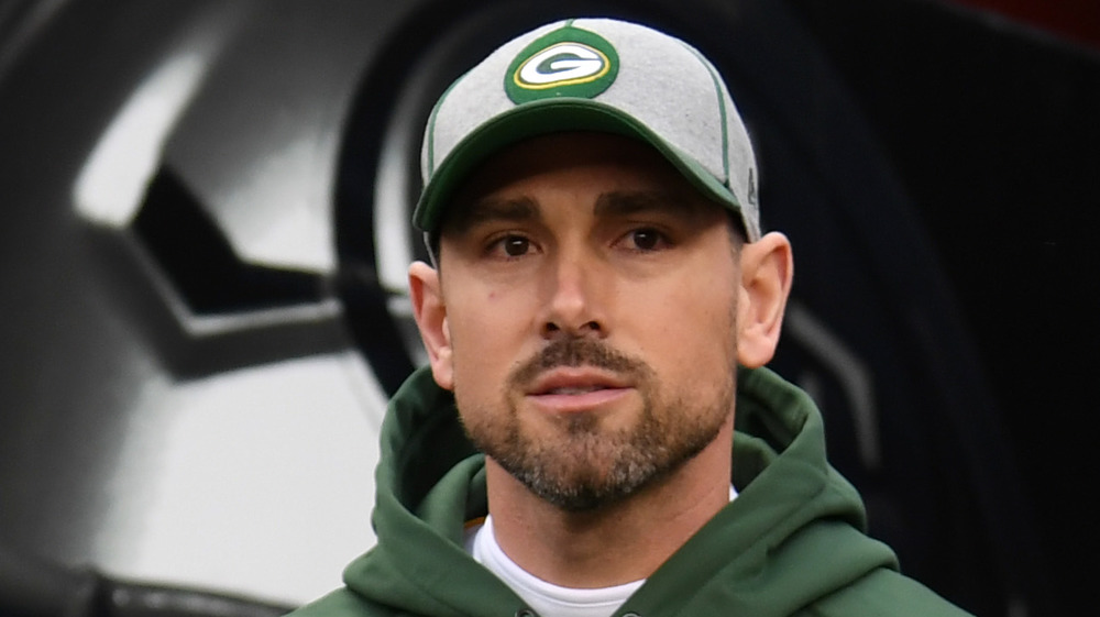 Matt LaFleur wears a Green Bay Packer's hat while walking in the club's tunnel