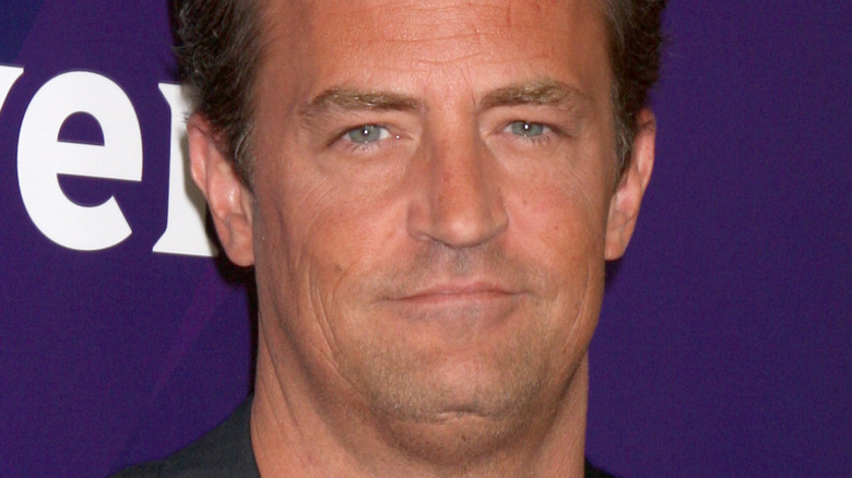 Matthew Perry posing for a picture at a press tour