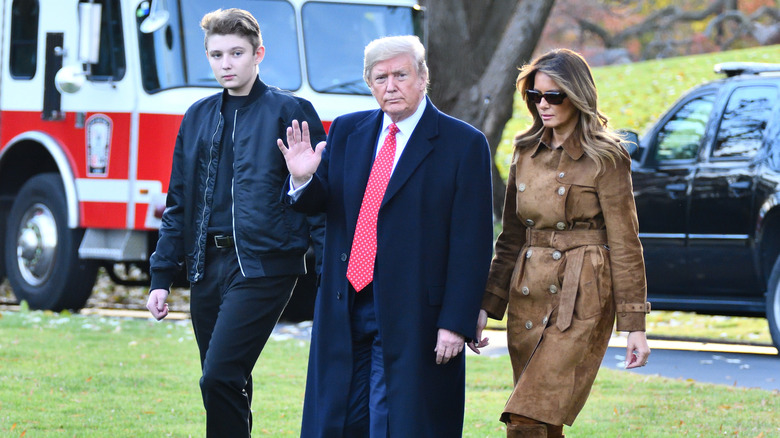 Barron, Donald, and Melania Trump walk on the White House lawn